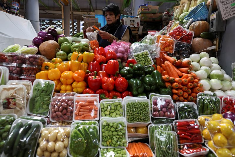 FILE PHOTO: A woman cuts carrots at her stand at the San Juan market, in Mexico City, Mexico December 26, 2024. REUTERS/Gustavo Graf/File Photo