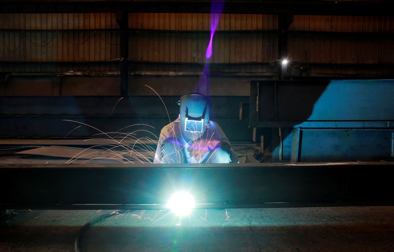 FILE PHOTO: A labourer welds an iron pillar at a building material factory in an industrial area in Dasna, in the central Indian state of Uttar Pradesh, India, January 9, 2019. Picture taken January 9, 2019. REUTERS/Adnan Abidi/File Photo
