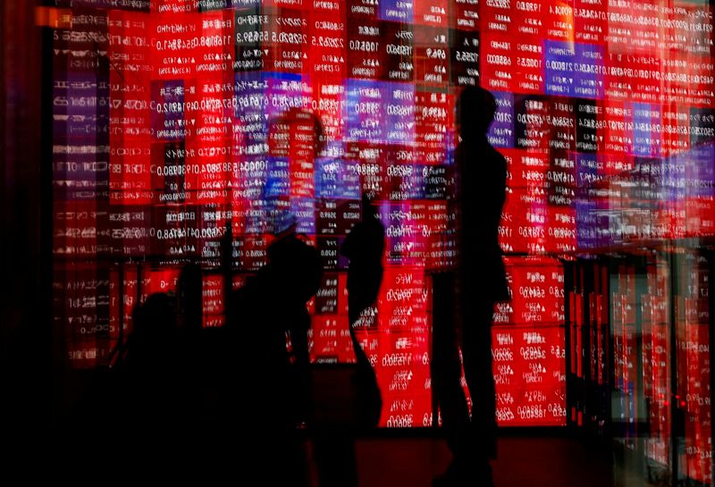 FILE PHOTO: Visitors and electronic screens displaying Japan's Nikkei stock quotation board are reflected on window glasses inside a building in Tokyo, Japan February 22, 2024. REUTERS/Issei Kato/File Photo