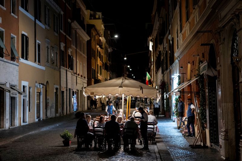 FILE PHOTO: People dine al fresco at a restaurant in Rome, Italy, May 14, 2025. REUTERS/Eloisa Lopez/File Photo