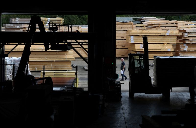 FILE PHOTO: A manufacturing technician walks past stacks of finished timber frame panels to be assembled later at a home construction site, at Donaldson Timber Systems in Witney, Britain, June 27, 2025. REUTERS/Suzanne Plunkett/File Photo