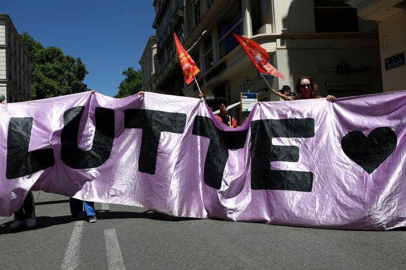 FILE PHOTO: Protesters hold a banner which reads "Struggle" during a demonstration organised by the CGT Spectacle labour union to denounce budget cuts in the cultural sector, in Avignon, France, July 16, 2025.  REUTERS/Manon Cruz/File Photo