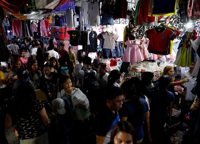 FILE PHOTO: Holiday shoppers walk through a dry goods night market in Baclaran, metro Manila, Philippines December 28, 2017.   REUTERS/Dondi Tawatao/File Photo