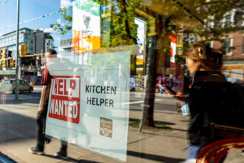 A help wanted sign hangs in a bar window along Queen Street West in Toronto Ontario, Canada June 10, 2022. REUTERS/Carlos Osorio/ File Photo