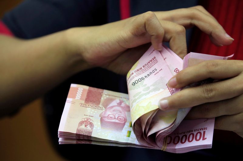 An employee counts Indonesian rupiah banknotes at a currency exchange office in Jakarta, Indonesia October 23, 2018. REUTERS/Beawiharta