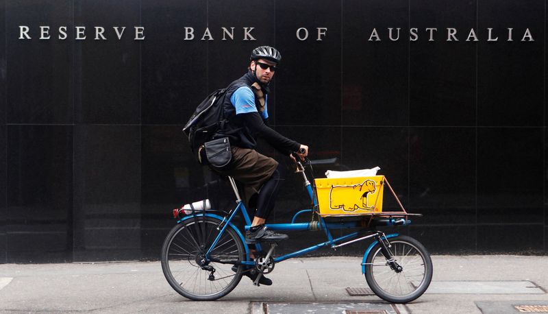 FILE PHOTO: A worker rides past the Reserve Bank of Australia building in central Sydney November 2, 2010. REUTERS/Daniel Munoz/File Photo
