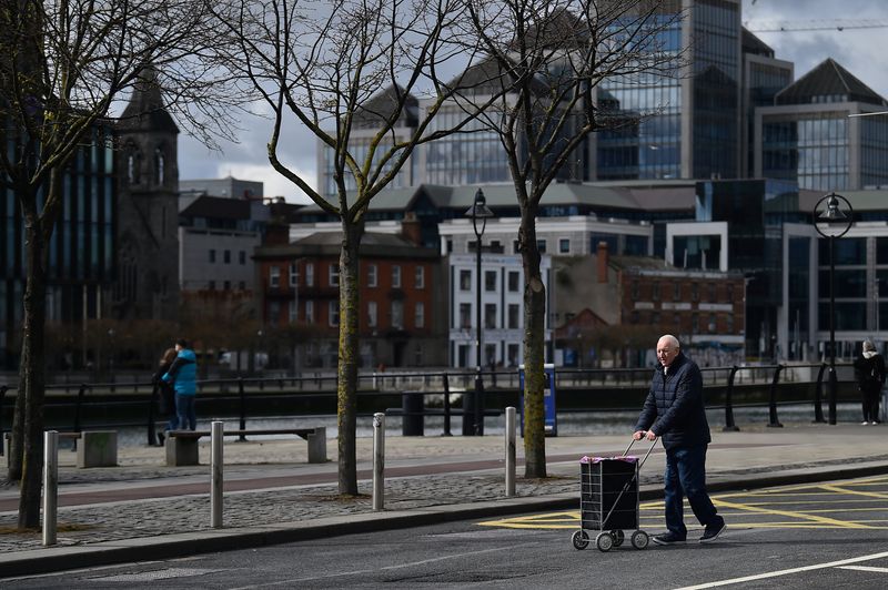 A man pushes a trolley across the road in the Irish Financial Services Centre (IFSC), in Dublin, Ireland, April 2, 2022. REUTERS/Clodagh Kilcoyne