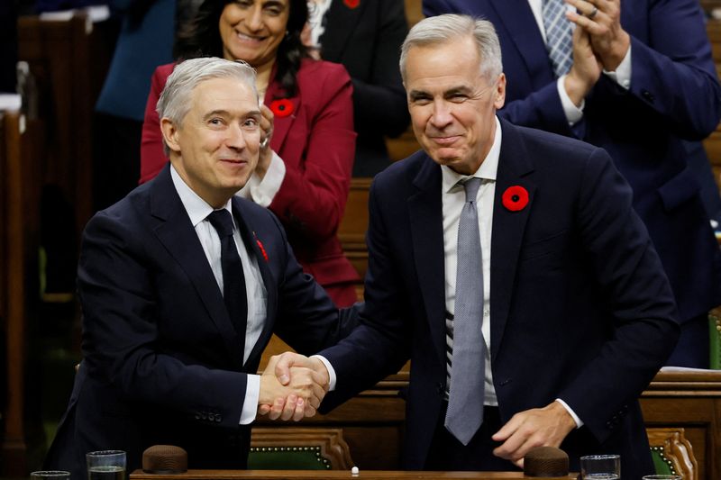 Minister of Finance Francois-Philippe Champagne shakes hands with Prime Minister Mark Carney at the conclusion of his speech after tabling the federal budget in the House of Commons on Parliament Hill in Ottawa, Ontario, Canada November 4, 2025. REUTERS/Blair Gable
