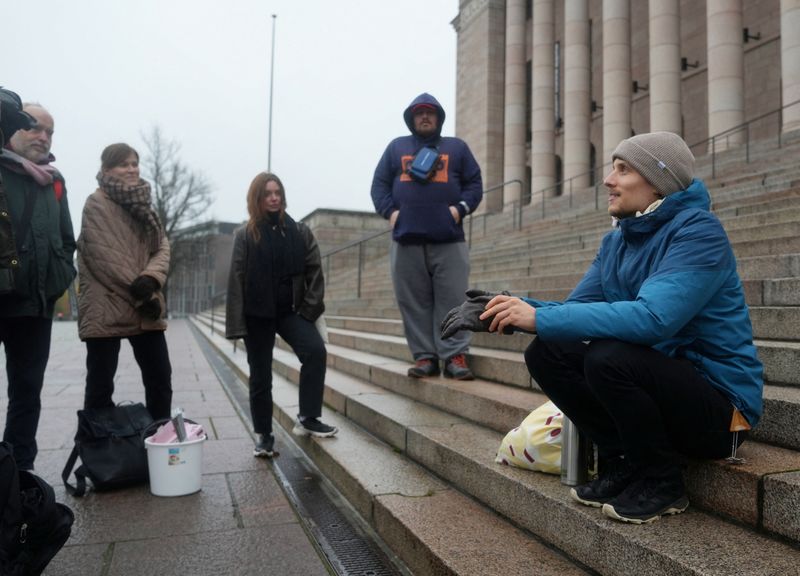 Juho-Pekka Palomaa, 33, sits on the steps in front of the Finnish parliament where he was holding a potluck protest to mark 1000 days of unemployment, in Helsinki, Finland, October 30, 2025. REUTERS/Tom Little