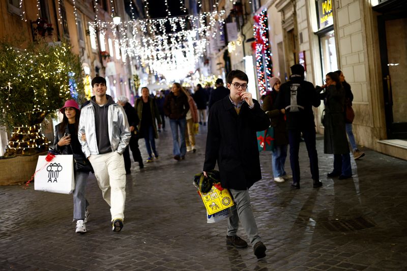 Shoppers walk along a shopping street ahead of Christmas in Rome, Italy, December 23, 2022. REUTERS/Guglielmo Mangiapane