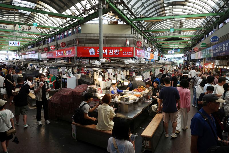 People shop at the Gwangjang market in Seoul, South Korea, August 7, 2025.   REUTERS/Kim Hong-Ji