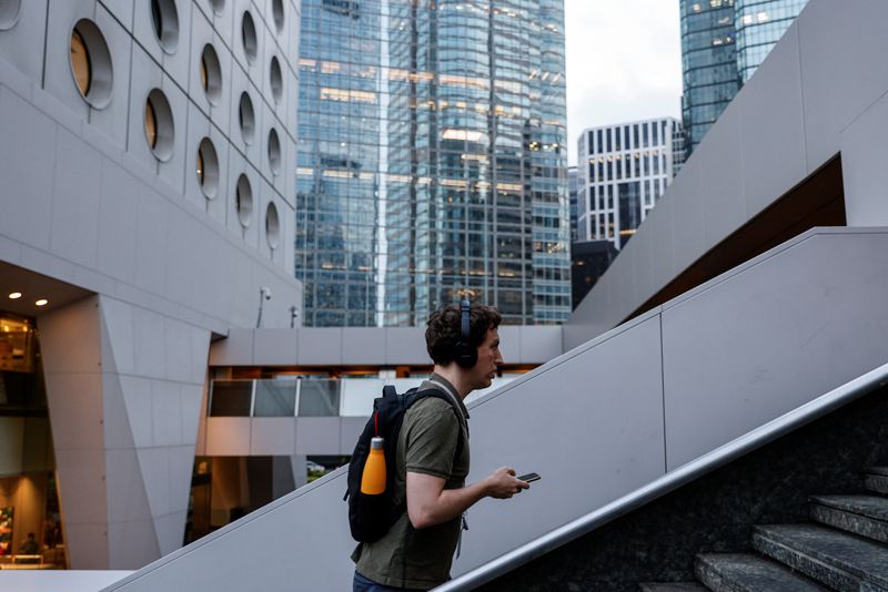 A man walks past a pedestrian footbridge in the financial central district of Hong Kong, China October 3, 2023. REUTERS/Tyrone Siu/File Photo