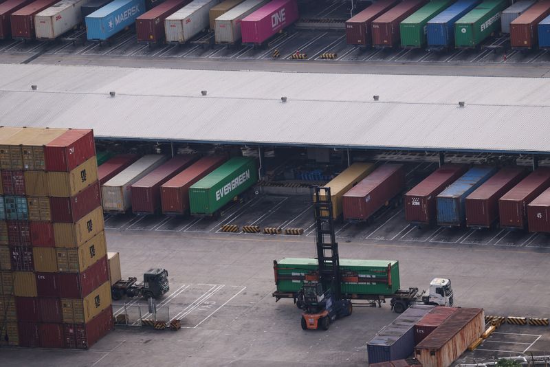 FILE PHOTO: A container handler unloads a container from a truck at a terminal of the Yantian port in Shenzhen, Guangdong province, China October 30, 2025. REUTERS/Tingshu Wang/File Photo