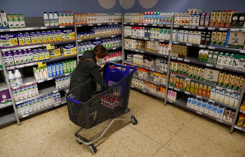 A woman takes some milk in a Caprabo supermarket in Barcelona, Spain, March 21, 2022. REUTERS/ Albert Gea