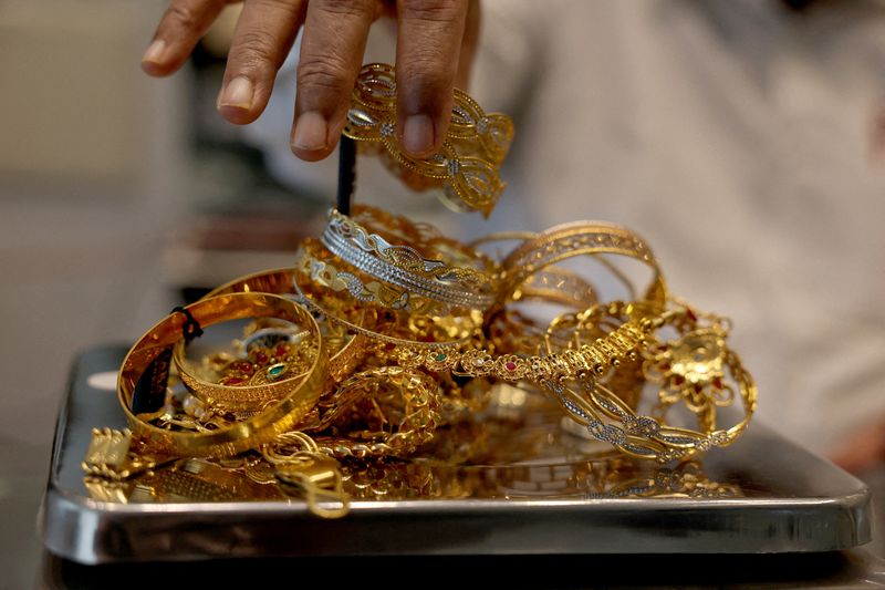 FILE PHOTO: A goldsmith weighs gold jewellery inside a showroom in Ahmedabad, India, July 31, 2025. REUTERS/Amit Dave/File Photo