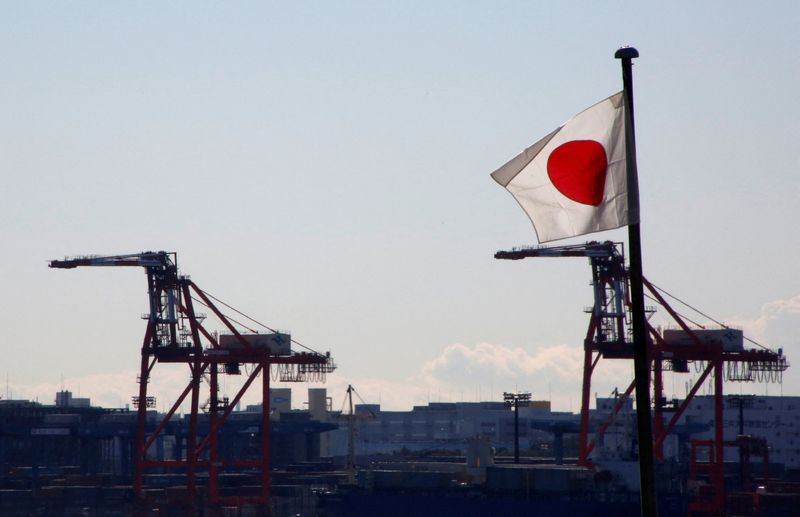 FILE PHOTO: Japan's national flag is seen in front of containers and cranes at an industrial port in Tokyo, Japan, January 25, 2017.  REUTERS/Kim Kyung-Hoon/File Photo