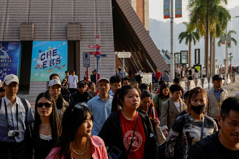 Tourists stroll through the streets of Tsim Sha Tsui, a bustling shopping hotspot, in Hong Kong, China December 5, 2023. REUTERS/Tyrone Siu