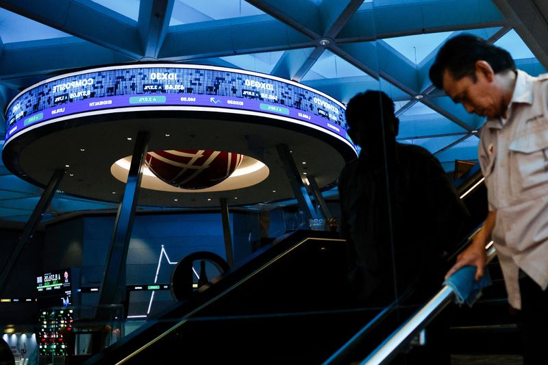 A worker wipes a handrail near the reflection of an electronic board displaying stock movement at the Indonesia Stock Exchange (IDX) in Jakarta, Indonesia, January 30, 2026. REUTERS/Ajeng Dinar Ulfiana