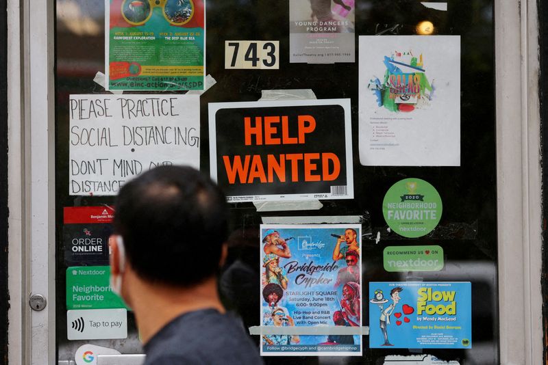 FILE PHOTO: A pedestrian passes a "Help Wanted" sign in the door of a hardware store in Cambridge, Massachusetts, U.S., July 8, 2022. REUTERS/Brian Snyder/File Photo