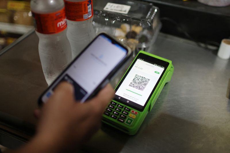 A person pays using their cell phone with the instant electronic payment mode known as PIX, at a store in Rio de Janeiro, Brazil April 1, 2024. REUTERS/Pilar Olivares