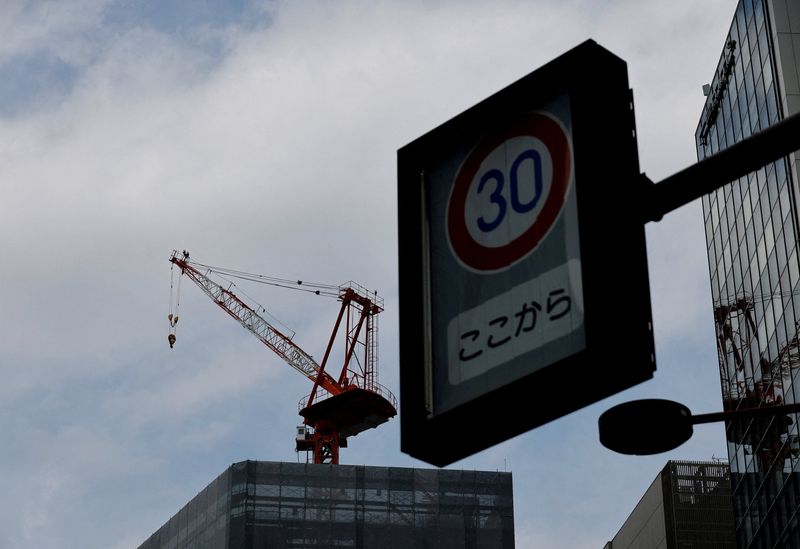 FILE PHOTO: A tower crane stands behind a speed limit sign in a commercial district in Tokyo, Japan, February 16, 2026. REUTERS/Kim Kyung-Hoon/File Photo