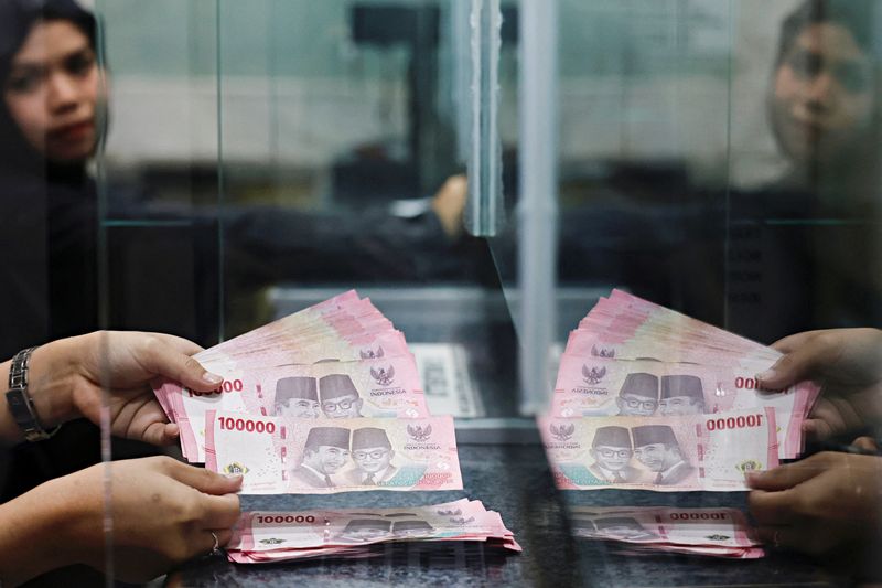 A teller counts rupiah bank notes at a money changer in Jakarta, Indonesia, January 20, 2026. REUTERS/Ajeng Dinar Ulfiana