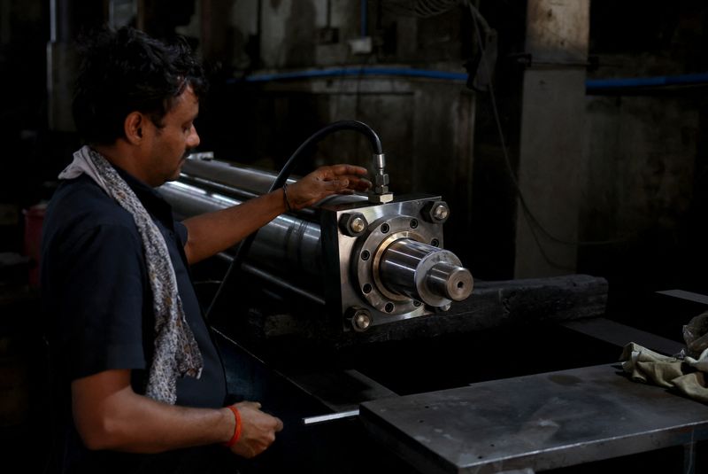 A worker checks the movement of a hydraulic cylinder before its packaging inside a manufacturing facility on the outskirts of Ahmedabad, India, August 7, 2025. REUTERS/Amit Dave