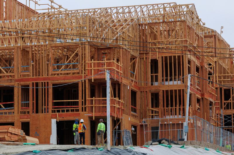 Constriction workers stand in front of a multi-unit residential housing development in Encinitas, California, U.S., October 6, 2025.  REUTERS/Mike Blake
