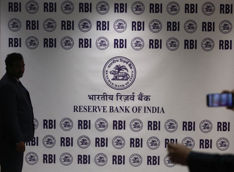 FILE PHOTO: A man stands in front of the Reserve Bank of India (RBI) logo inside its headquarters in Mumbai, India, February 6, 2026. REUTERS/Francis Mascarenhas/File Photo
