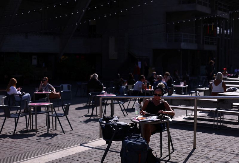 People sit outside a cafe on the Southbank in London, Britain, August 27, 2024. REUTERS/Hannah McKay