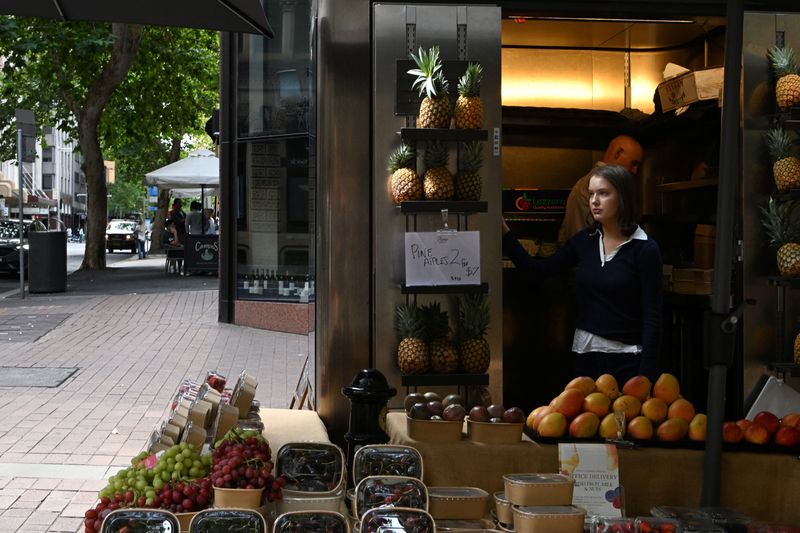 A woman stands inside a shop selling fruits on a street in Sydney’s central business district, Australia, February 3, 2026. REUTERS/Flavio Brancaleone