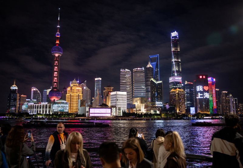 People walk at the Bund by the Huangpu river with skyscrapers of the Lujiazui financial district in the background, in Shanghai, China, November 4, 2025. REUTERS/Maxim Shemetov