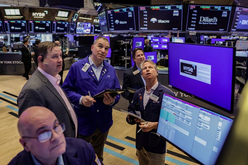 Traders work on the floor at the New York Stock Exchange (NYSE) in New York City, U.S., March 24, 2026. REUTERS/Jeenah Moon