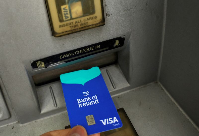 FILE PHOTO: A person uses their bank card at an ATM outside a branch of Bank of Ireland, in Newbridge, Ireland, August 16, 2023. REUTERS/Clodagh Kilcoyne//File Photo