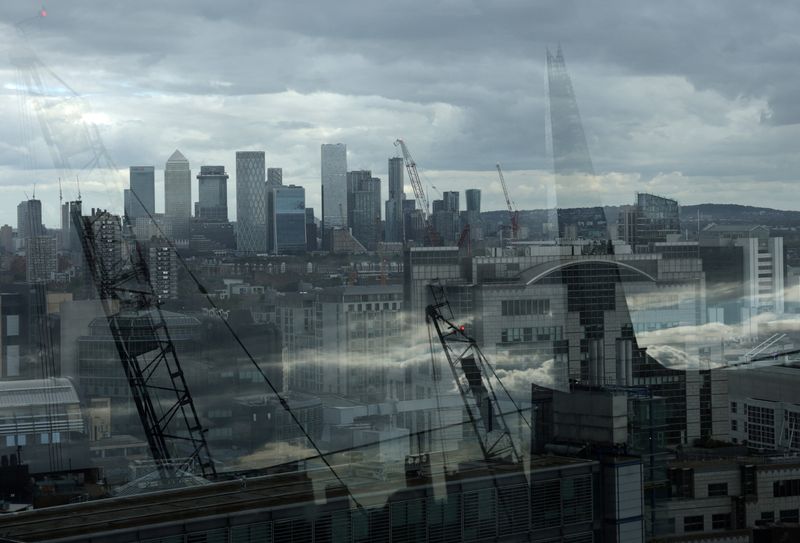 Skyscrapers of the Canary Wharf commercial district are seen with The Shard building and construction cranes reflected in a perimeter glass wall of the viewing area of Garden at 120, in the City of London financial district, in London, Britain, September 23, 2025. REUTERS/Toby Melville