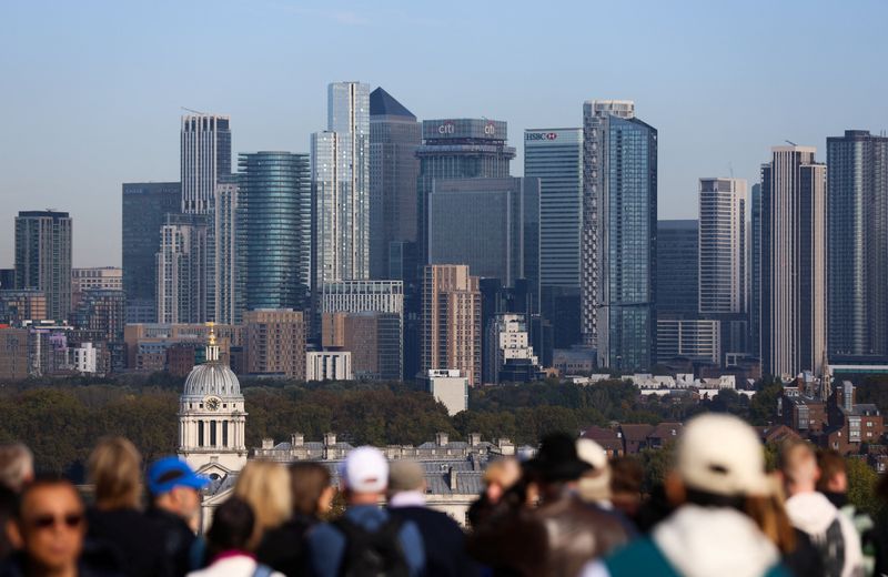 Tourists gather at the General Wolfe Statue viewpoint overlooking Canary Wharf, in Greenwich Park, London, Britain, September 30, 2025. REUTERS/Corey Rudy