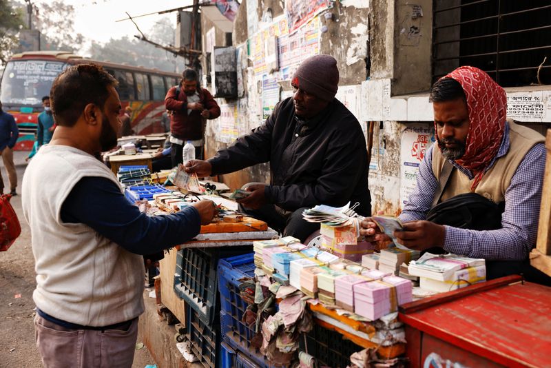 Street vendors sell and exchange bank notes of local currency in Dhaka, Bangladesh, January 1, 2025. REUTERS/Mohammad Ponir Hossain