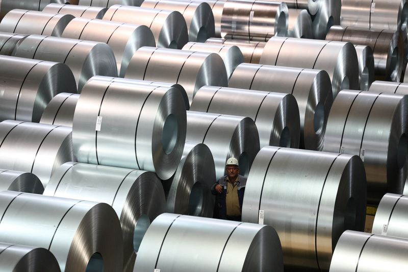 A steel worker walks through an alley of steel coils at the storage and distribution facility of German steel maker ThyssenKrupp in Duisburg, Germany, November 16, 2023.     REUTERS/Wolfgang Rattay
