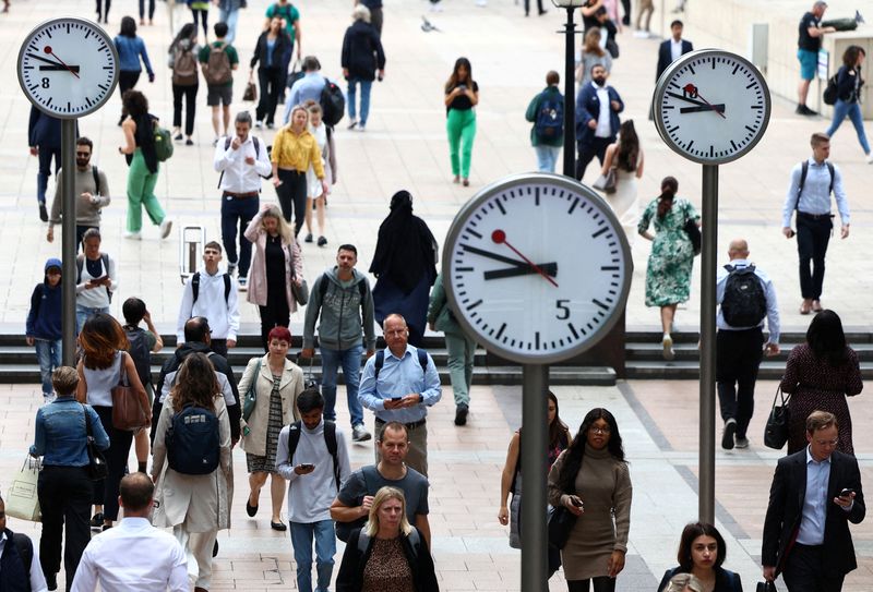 FILE PHOTO: Workers walk through the Canary Wharf financial district in London, Britain, August 3, 2023. REUTERS/Toby Melville/File Photo
