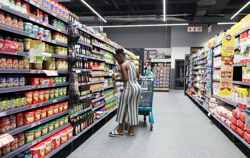 Zizo Bhungane, a shopper, picks an item at the grocery section, as she shops at a Checkers outlet in Sandton, South Africa, March 8, 2026. REUTERS/Siphiwe Sibeko