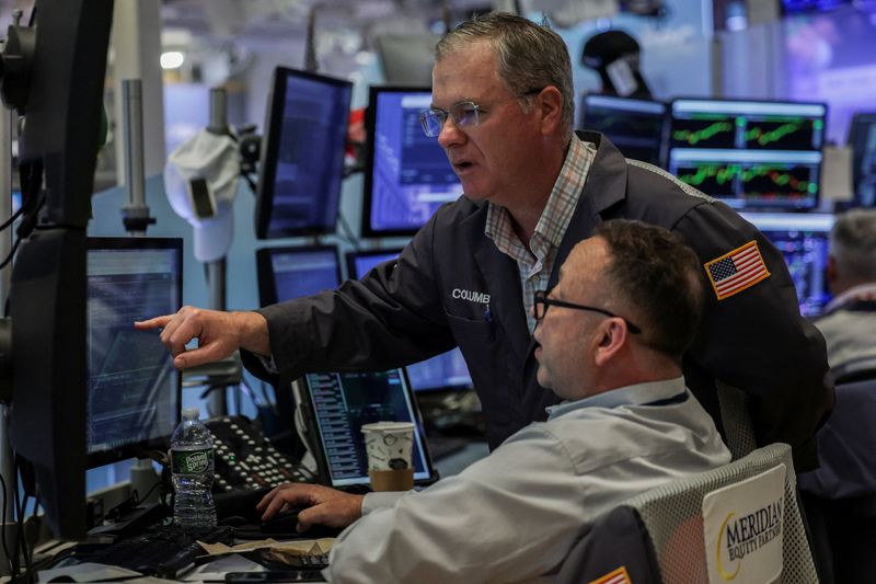 Traders work on the floor at the New York Stock Exchange (NYSE) in New York City, U.S., April 16, 2026. REUTERS/Jeenah Moon