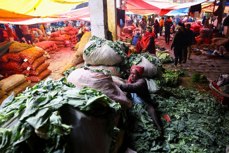FILE PHOTO: A man sorts vegetables at a wholesale fruit and vegetable market in the old quarters of Delhi, India, February 1, 2026. REUTERS/Anushree Fadnavis/File Photo