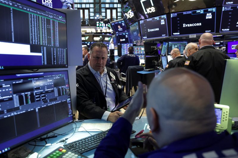 Traders work on the floor at the New York Stock Exchange (NYSE) in New York City, U.S., April 23, 2026. REUTERS/Jeenah Moon/File Photo