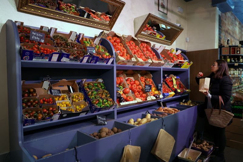 FILE PHOTO: A customer shops for vegetables at gourmet grocery store Andreas, in London, Britain, March 28, 2024. REUTERS/Isabel Infantes/File Photo
