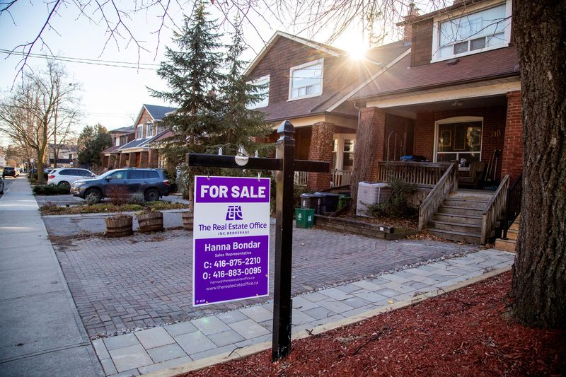 FILE PHOTO: A for sale sign is displayed outside a home in Toronto, Ontario in Toronto, Ontario, Canada December 13, 2021.  REUTERS/Carlos Osorio/File Photo