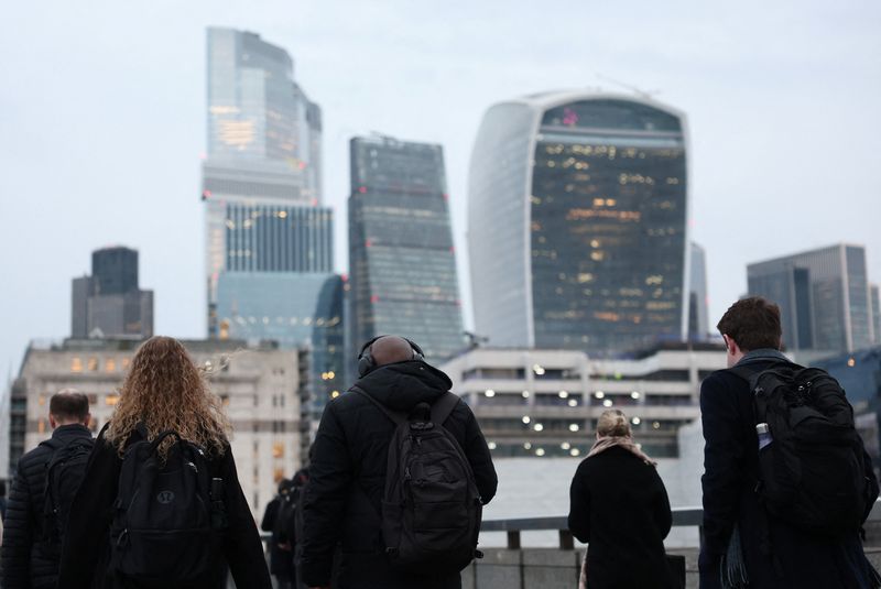 Workers cross London Bridge during the morning rush-hour with skyscrapers of the City of London financial district seen behind, in London, Britain, December 16, 2025. REUTERS/Toby Melville