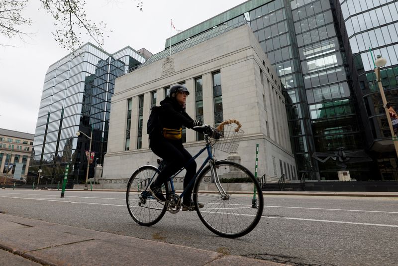 FILE PHOTO: A cyclist rides past the Bank of Canada building in Ottawa, Ontario, Canada May 8, 2025. REUTERS/Blair Gable/ File Photo