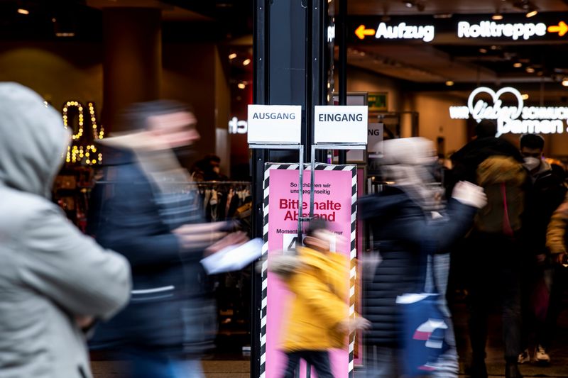 FILE PHOTO: People walk past a store in the pedestrian zone in Munich, Germany, December 6, 2021. REUTERS/Lukas Barth/ File Photo