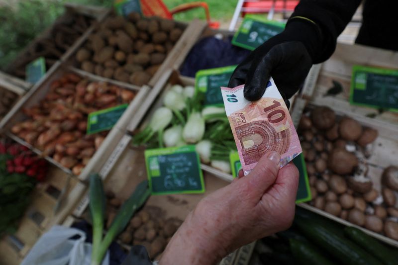 A shopper pays with a ten Euro bank note at a local market in Nantes, France, April 3, 2026. REUTERS/Stephane Mahe
