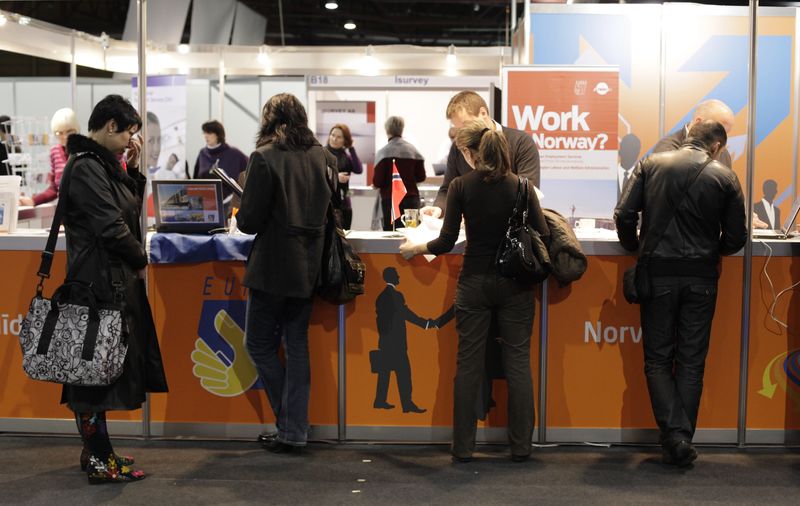 People talk to European Employment Services (EURES) consultants at the "Job and Career Advice 2010" fair in Riga November 13, 2010. The registered unemployment rate in the country was 14.3% at the end of October 2010 for the total economically active population, Latvia's State Employment Agency reported to media. REUTERS/Ints Kalnins (LATVIA - Tags: EMPLOYMENT BUSINESS)